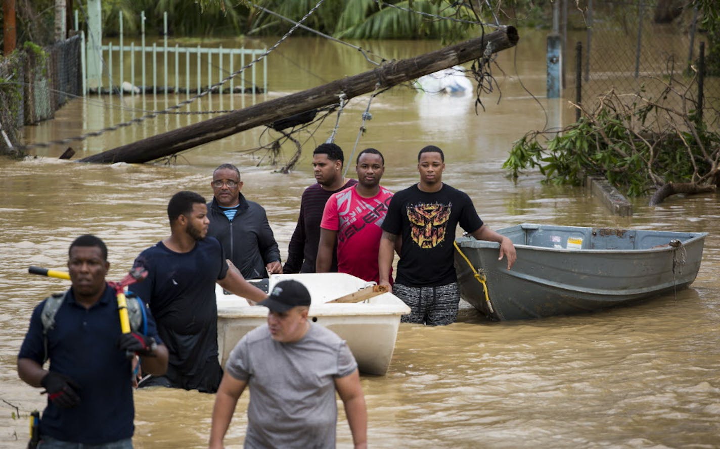 Men walk in a flooded area, searching for people to rescue after Hurricane Maria, in Loiza, Puerto Rico, Sept. 21, 2017. The island remained in the throes of chaos and devastation Thursday as the remnants of Hurricane Maria continued to dump rain on the island &#xf3; up to three feet in some areas. (Erika P. Rodriguez/The New York Times)