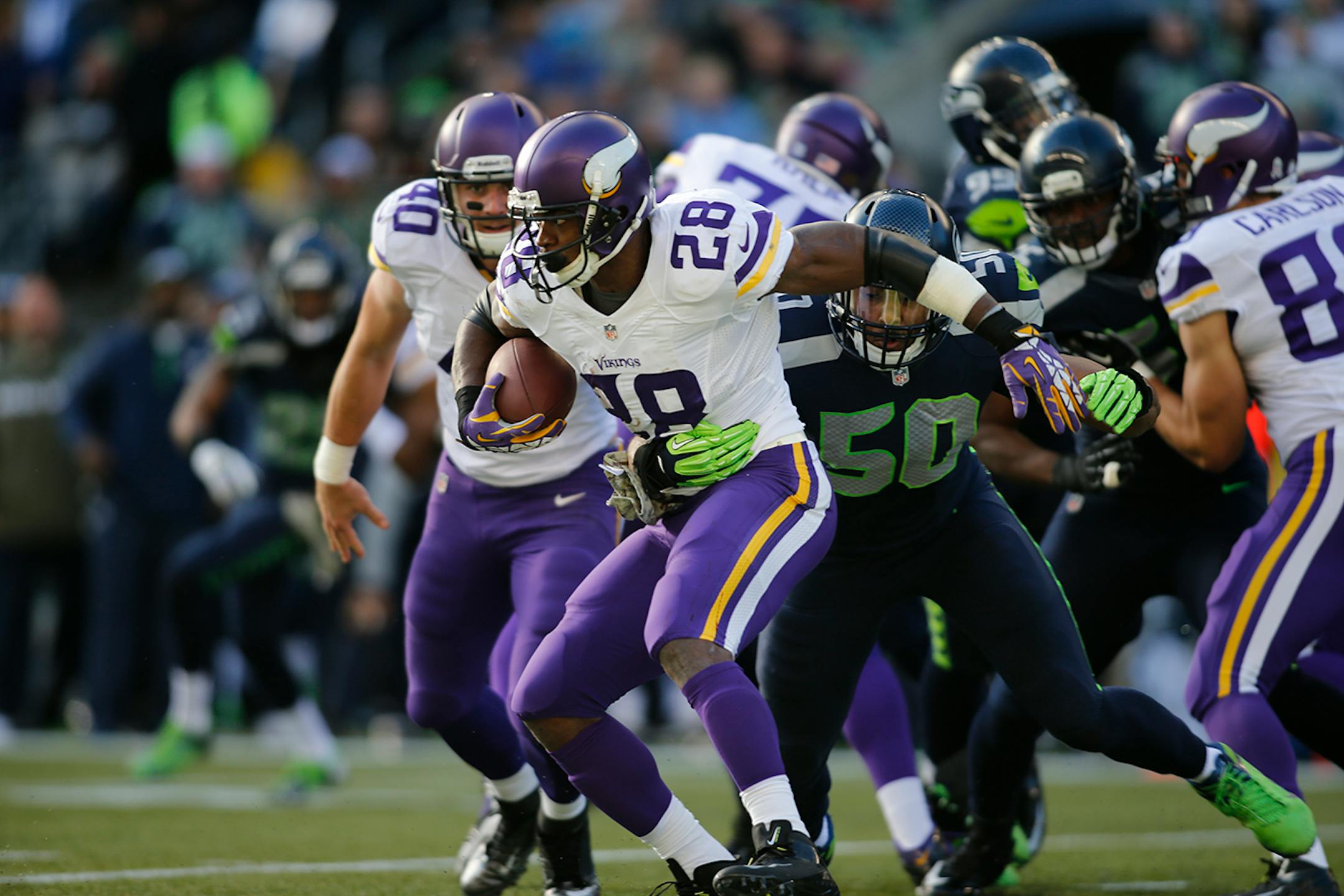 Adrian Peterson carries the ball with Seattle Seahawks' K.J. Wright hitting him in the first half of an NFL football game, Sunday, Nov. 17, 2013, in Seattle.