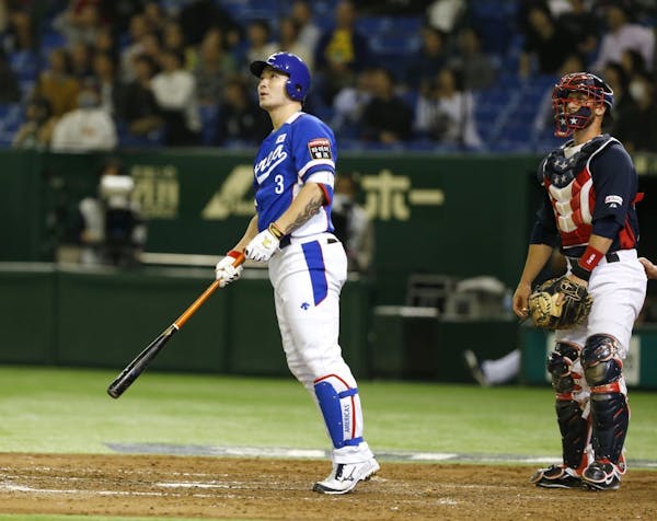 South Korea's Byung Ho Park watches the flight of his three-run home run with USA catcher Dan Rohlfing in the fourth inning of their final game at the