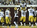 Iowa offensive lineman Justin Britt (63) lifted running back Tyler Goodson (15) into the air after Goodson's second quarter rushing touchdown