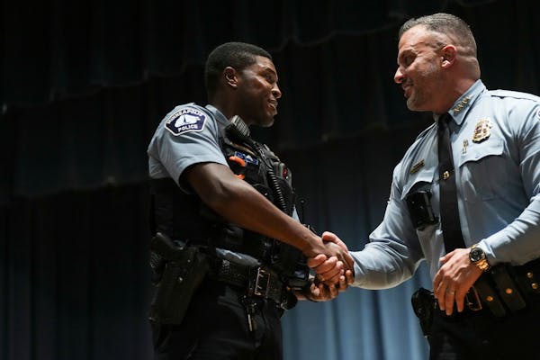 Minneapolis police officer Jamal Mitchell, left, was photographed in a 2023 Minneapolis Police awards ceremony where he was presented with a Lifesavin