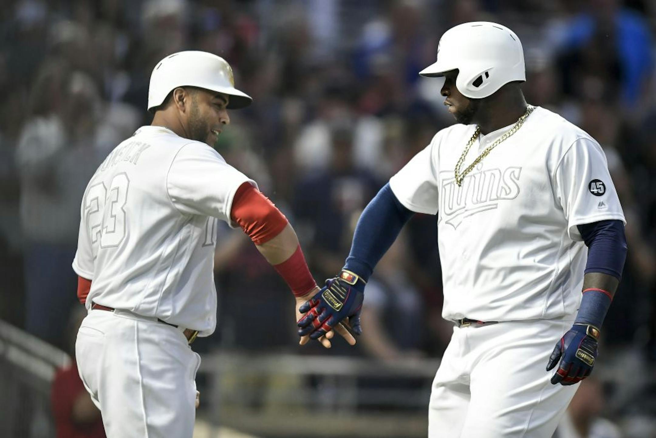 Minnesota Twins third baseman Miguel Sano (22) celebrated with designated hitter Nelson Cruz (23) after Sano's 3-run home run in the bottom of the fifth inning against the Detroit Tigers.