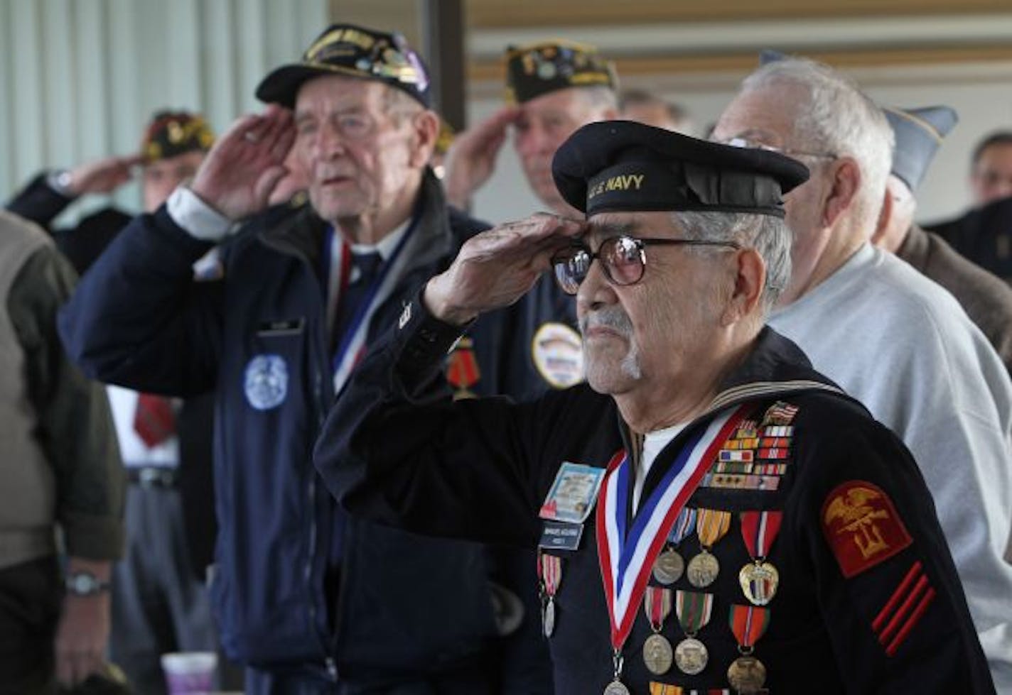 Eighty-four-year-old Manuel Aguirre, of St. Paul, saluted with other World War II veterans during a Pearl Harbor Remembrance Day ceremony Monday in St. Paul for service personnel honoring those who were at the harbor when it was attacked Dec. 7, 1941. Ed Wentzlaff, 92, of Milaca, is one of only 20 USS Arizona survivors still alive.