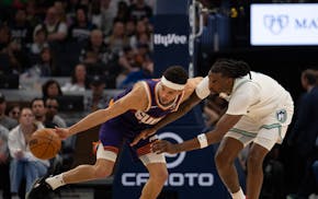 Suns guard Devin Booker (1) steals the ball from Timberwolves center Naz Reid (11) in the fourth quarter in Game 1 on Saturday. Despite the 25-point l