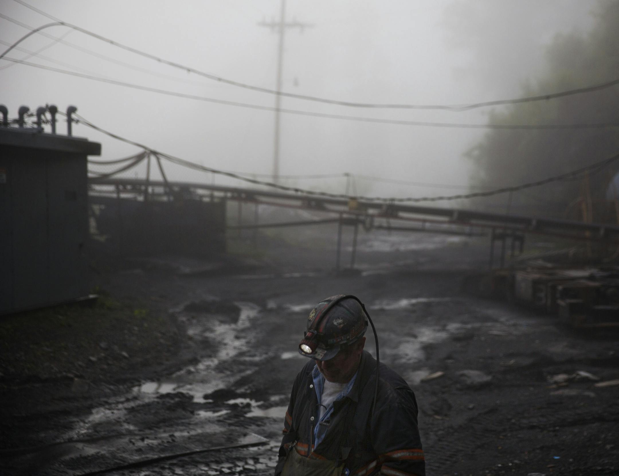 CLIMATE CHANGE: In this Thursday, May 12, 2016 photo, coal miner Scott Tiller walks through the morning fog before going underground in a mine less than 40-inches high in Welch, W.Va. For over a century, life in Central Appalachia has been largely defined by the ups and downs of the coal industry. There is a growing sense in these mountains that for a variety of reasons, economic, environmental, political, coal mining will not rebound this time. Coal's slump is largely the result of cheap natura