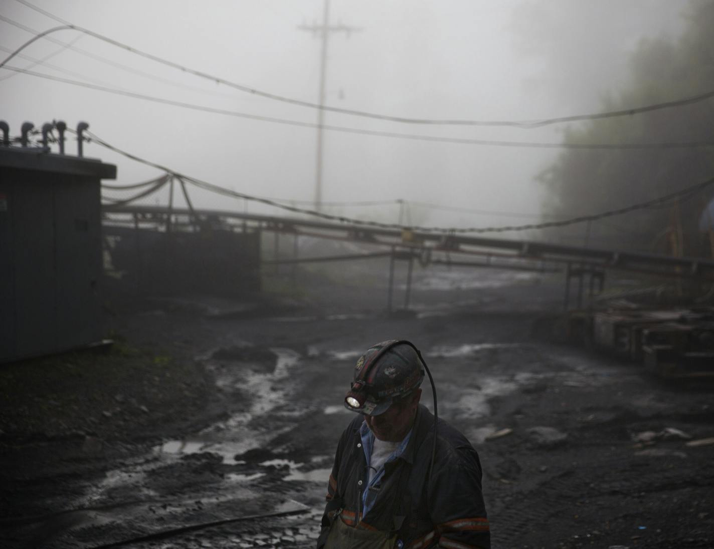 CLIMATE CHANGE: In this Thursday, May 12, 2016 photo, coal miner Scott Tiller walks through the morning fog before going underground in a mine less than 40-inches high in Welch, W.Va. For over a century, life in Central Appalachia has been largely defined by the ups and downs of the coal industry. There is a growing sense in these mountains that for a variety of reasons, economic, environmental, political, coal mining will not rebound this time. Coal's slump is largely the result of cheap natura