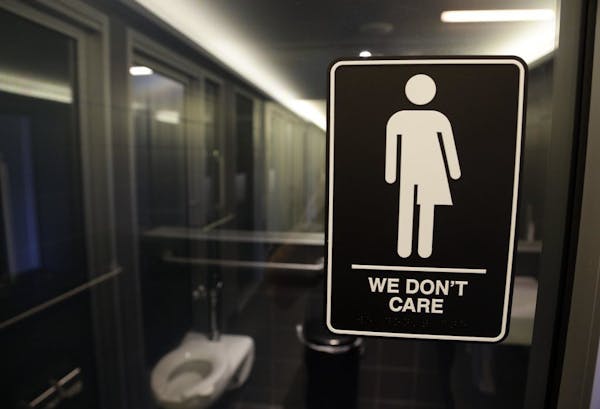 In this Thursday, May 12, 2016 file photo, signage is seen outside a restroom at 21c Museum Hotel in Durham, N.C. Ten states sued the federal governme