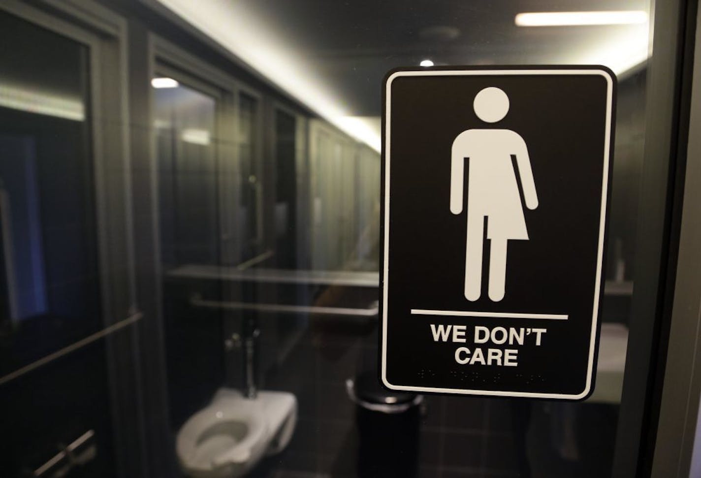 In this Thursday, May 12, 2016 file photo, signage is seen outside a restroom at 21c Museum Hotel in Durham, N.C. Ten states sued the federal government Friday, July 8, 2016 over rules requiring public schools to allow transgender students to use restrooms conforming to their gender identity, joining a dozen other states in the latest fight over LGBT rights.