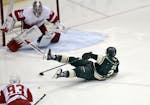 After being tripped on a breakaway attempt the Minnesota Wild's Charlie Coyle tries to control the puck while headed towards Detroit Red Wings goalie 