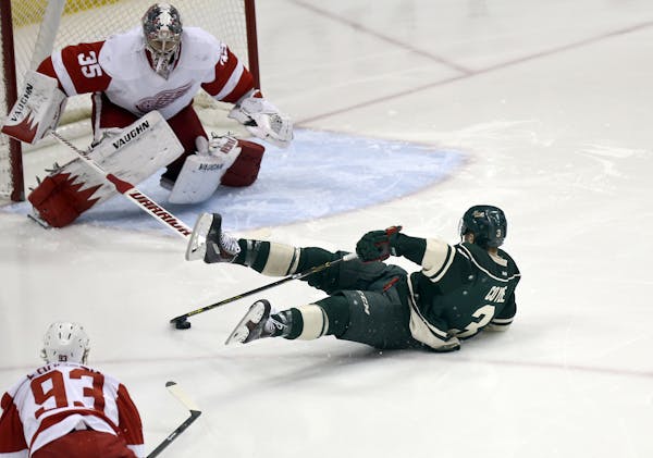 After being tripped on a breakaway attempt the Minnesota Wild's Charlie Coyle tries to control the puck while headed towards Detroit Red Wings goalie 