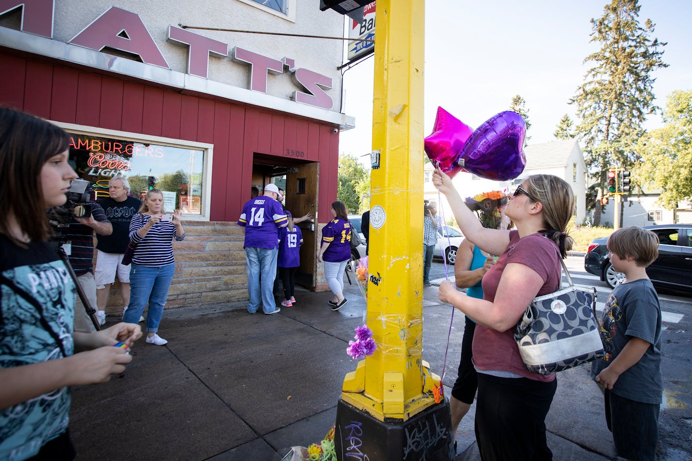 Those who identified only as extended members of the family of Sheryl and Kenneth Carpentier, two of the victims, put up balloons and flowers on the growing memorial outside of Matt's Bar.