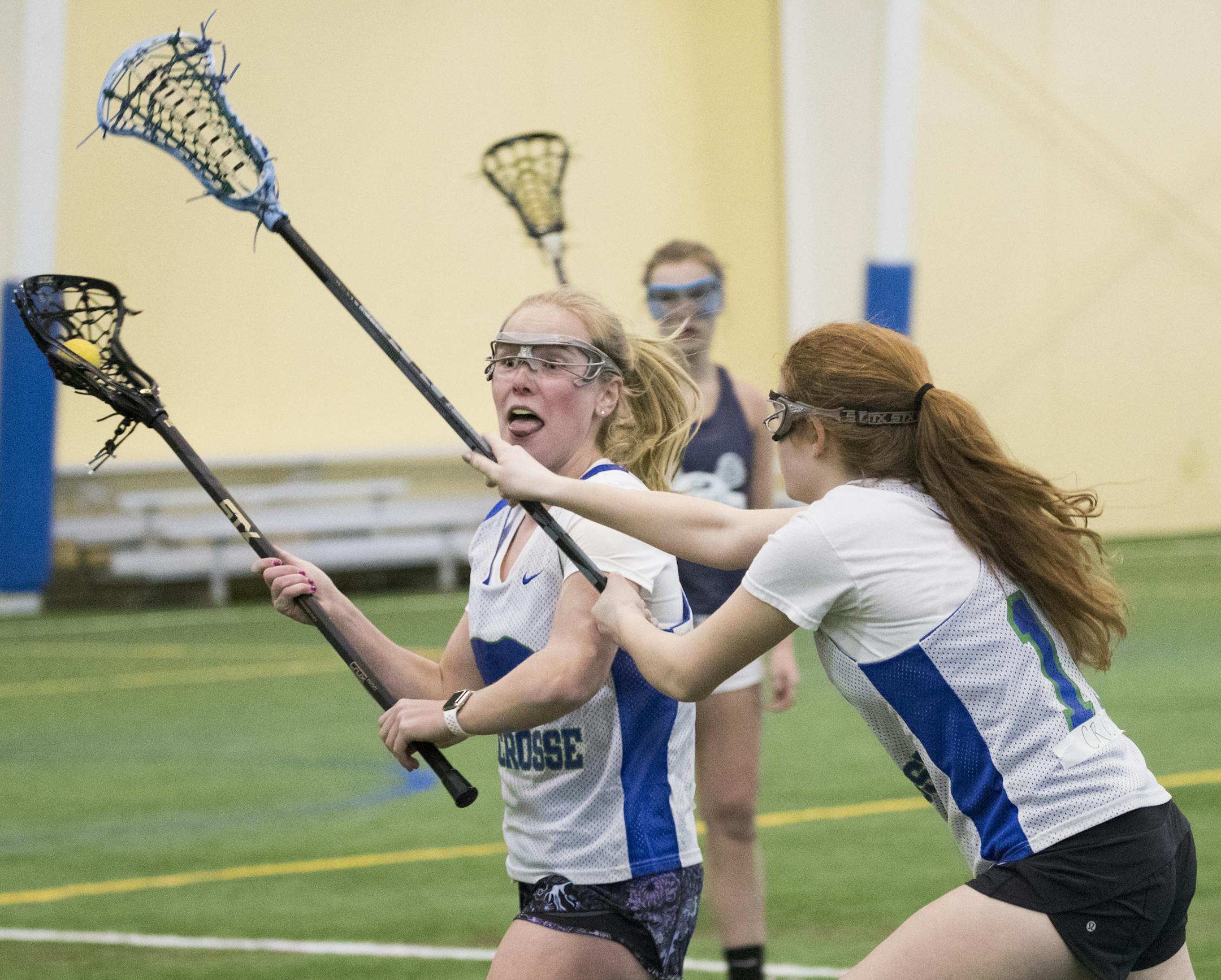 Sophie Skallerud, left, and Payton Crosby battle during a drill. ] LEILA NAVIDI ï leila.navidi@startribune.com BACKGROUND INFORMATION: Blake girls lacrosse tryouts at Champion Hall in Eden Prairie on Wednesday, April 4, 2018.