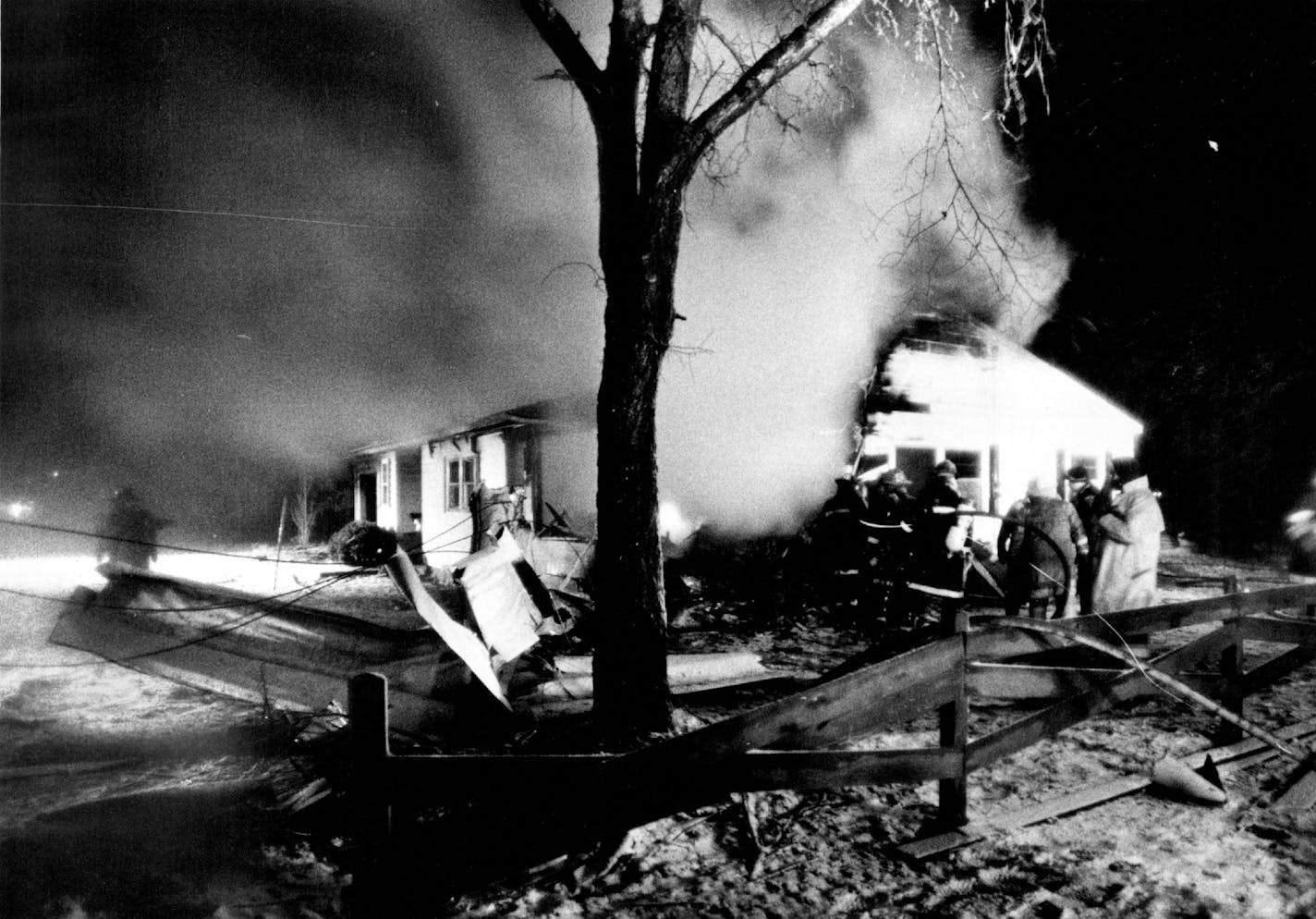 April 9, 1980 Power lines were snagged on part of the wreckage of a plane, left center, that crashed into a house, background, near Crystal Airport and burned Tuesday night. Two people were killed and four others were injured Tuesday night after a small plane crashed while taking off from the Crystal Airport in suburban Minneapolis during a snowstorm, officials said. Witnesses said the Cessna 340 was going northwest when it hit some trees and power lines, then crashed into a house at 6400 63rd Av. Nã Brooklyn Park. April 8, 1980 John Croft, Minneapolis Star Tribune