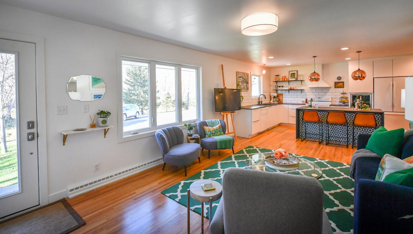 With the removal of a massive two-sided brick fireplace, the living room of this 1960s duplex near Excelsior now flows into the new black-and-white kitchen.