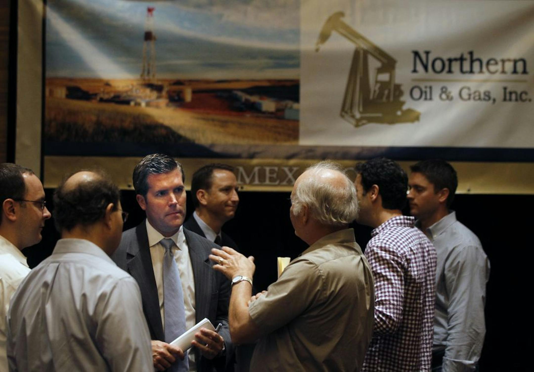 At the Northern Oil and Gas Inc. shareholders' meeting, CEO Michael Reger(blue tie) chatted with attendees. Northern Oil and Gas Inc. reported success Monday at five oil wells in North Dakota and two in Montana as its CEO predicted a record-breaking year of production growth. In a statement, CEO Michael Reger said the seven wells represent an expansion of an oil field in eastern Montana and continued success in North Dakota, the two states where the Wayzata-based company owns well interests. "We