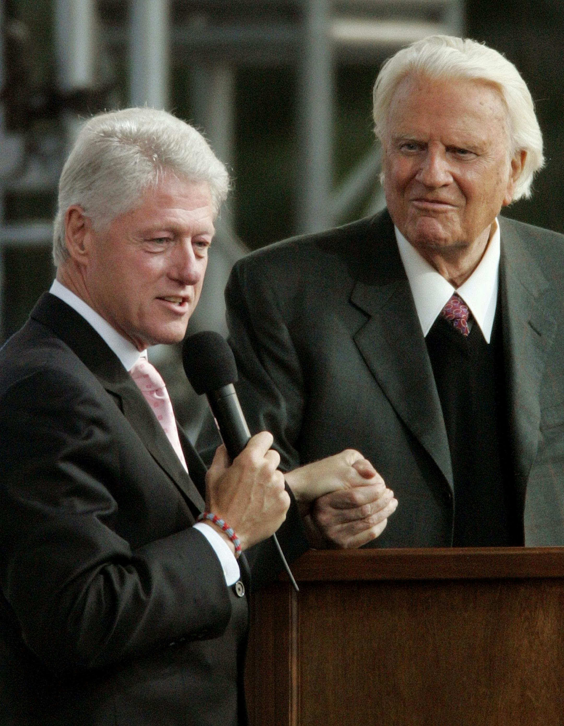 Former president Bill Clinton, left, speaks alongside the Rev. Billy Graham on the second night of the Greater New York Billy Graham Crusade Saturday, June 25, 2005 at Flushing Meadows Corona Park in New York borough of Queens.