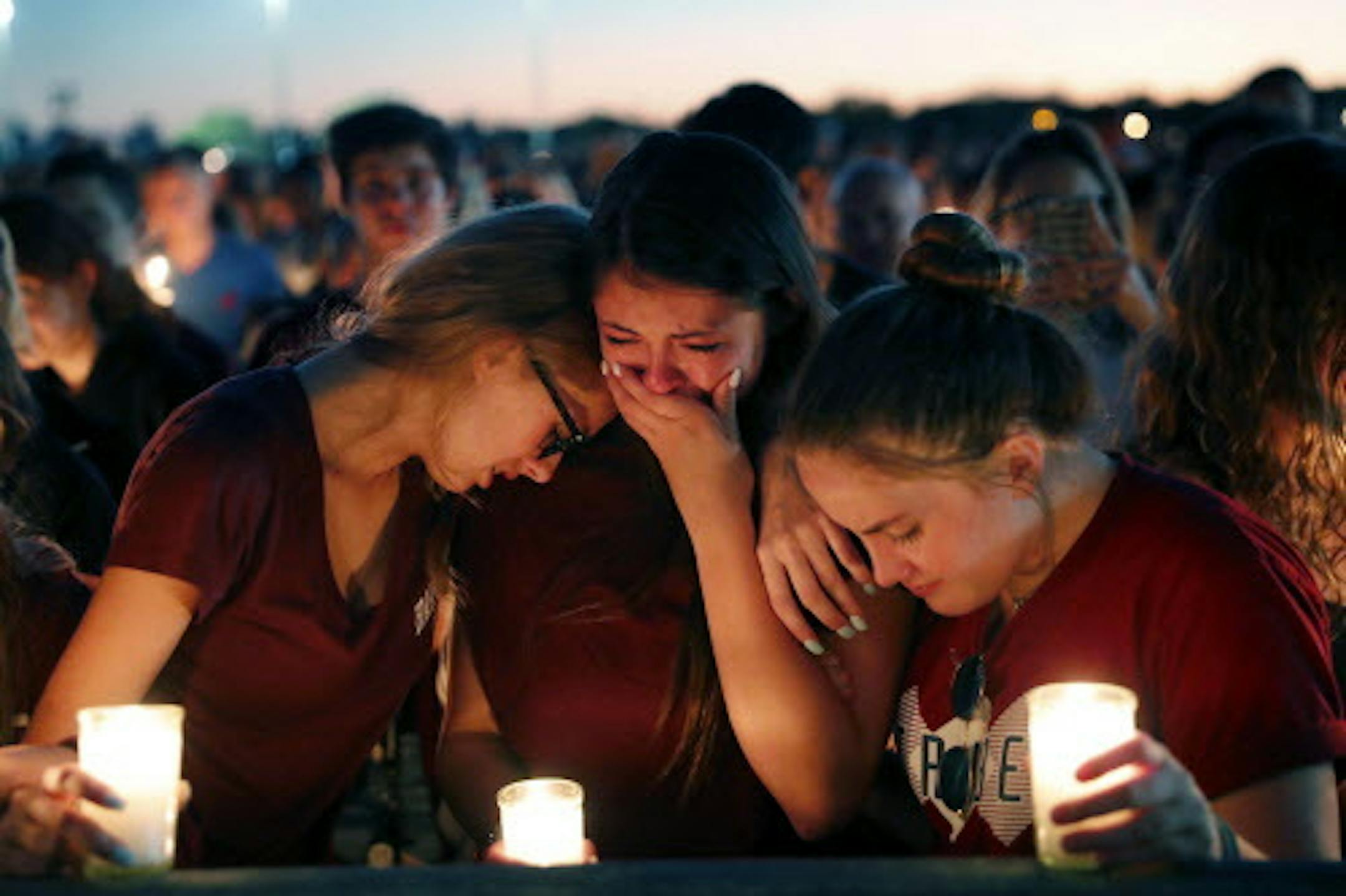 Students console each other as they weep during a candlelight vigil for the victims of the Wednesday shooting at Marjory Stoneman Douglas High School, in Parkland, Fla., Thursday, Feb. 15, 2018. Nikolas Cruz, a former student, was charged with 17 counts of premeditated murder on Thursday. (AP Photo/Gerald Herbert)