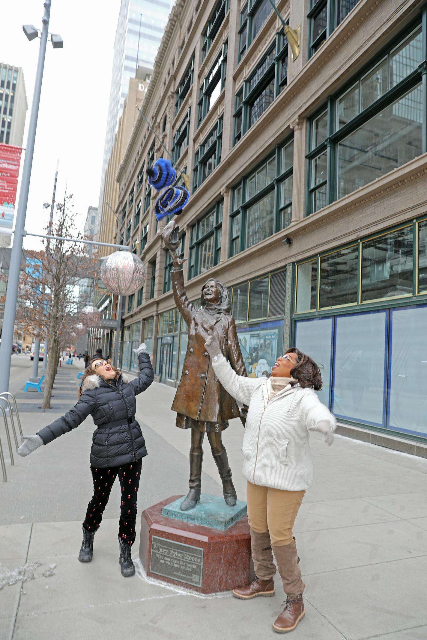 Oprah Winfrey and Tiny Fey engaged in some tossing of hats at the Mary Tyler Moore statue on Friday in Minneapolis.