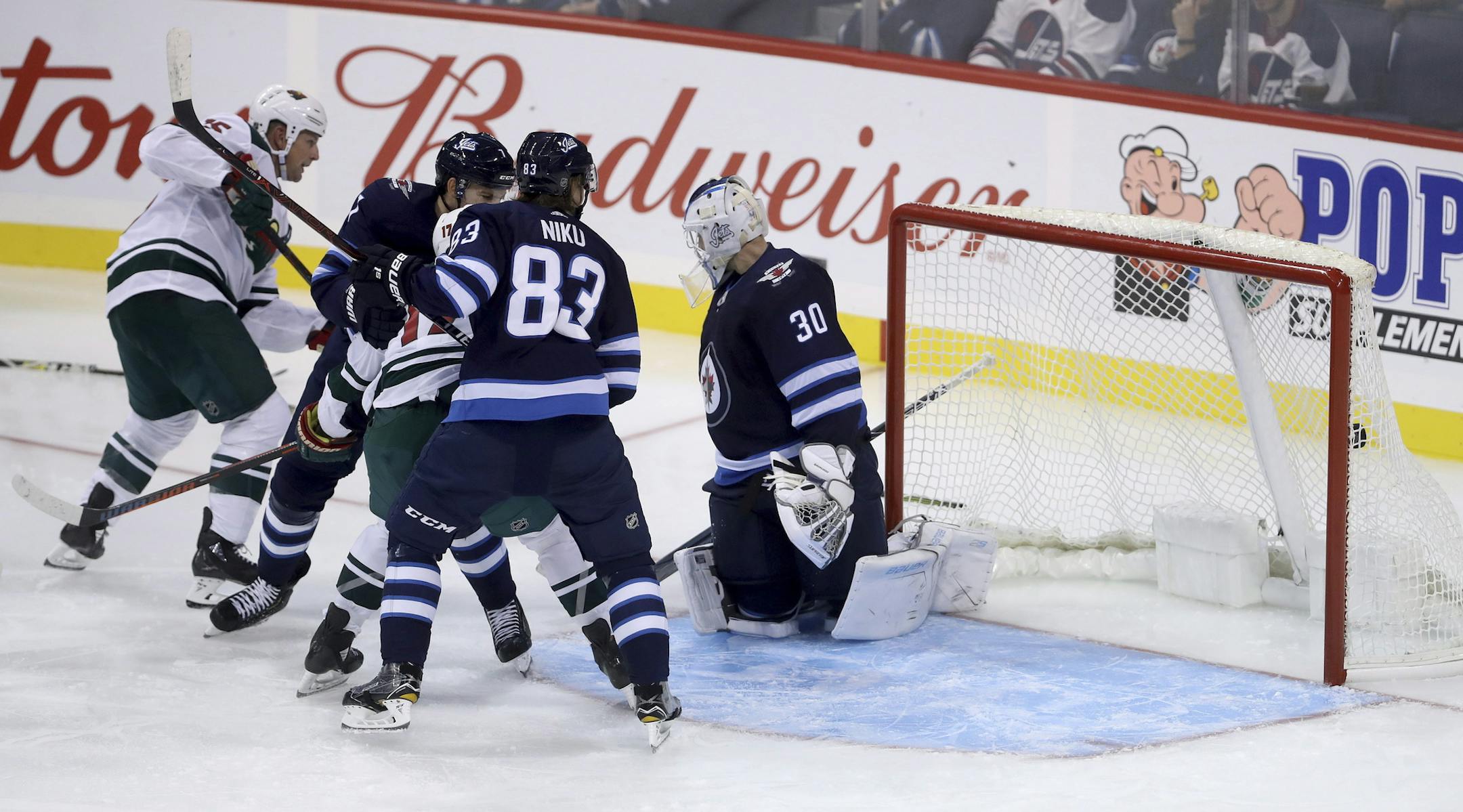 Minnesota Wild's Matt Hendricks (15) scores against his former club as he puts the puck past Winnipeg Jets goaltender Laurent Brossoit (30) during the third period of an NHL preseason hockey game, Monday, Sept. 17, 2018, in Winnipeg, Manitoba. (Trevor Hagan/The Canadian Press via AP)