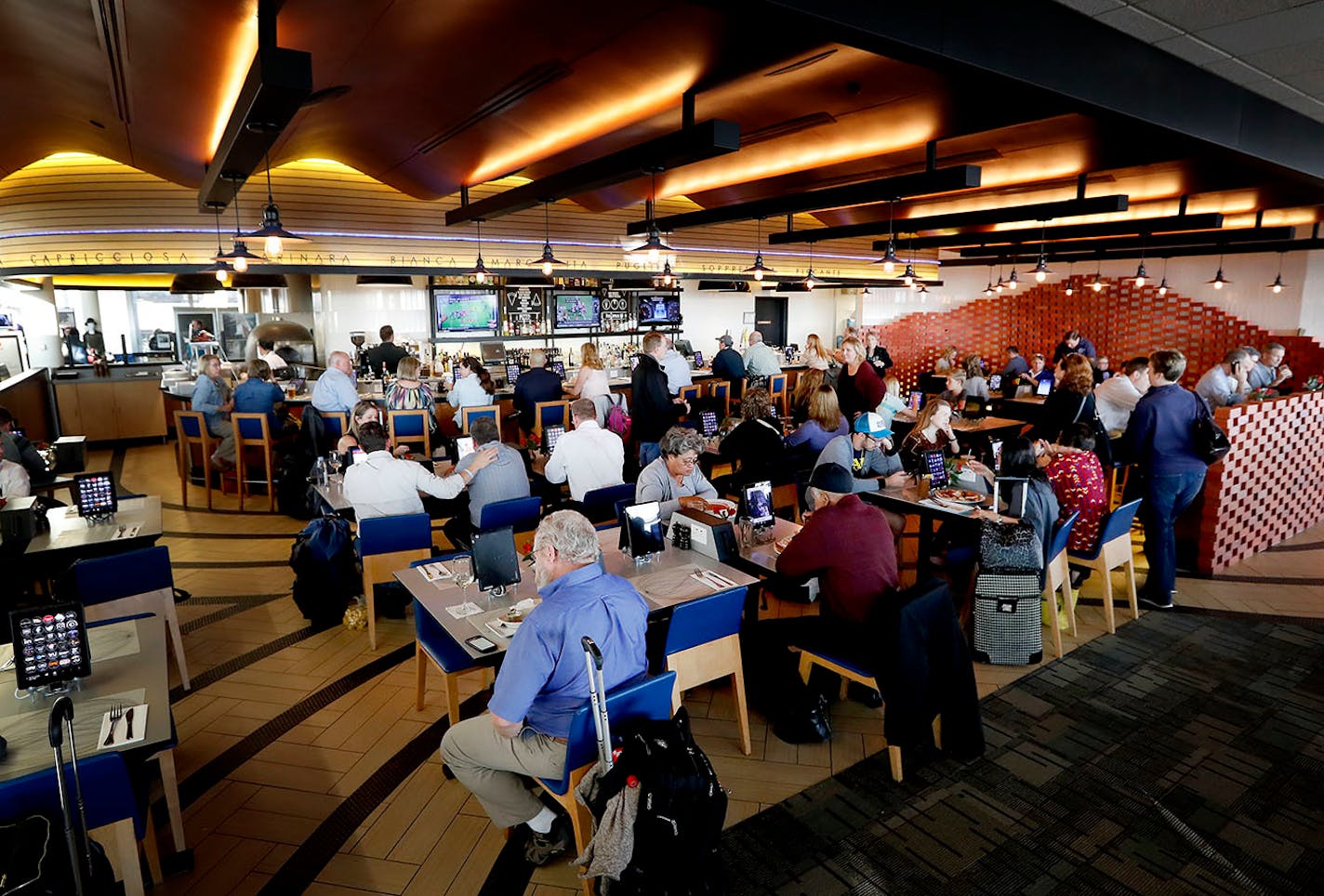 Travelers hang out at Vero, the airport enterprise from Ann Kim of Pizzeria Lola, in Concourse G at MSP.