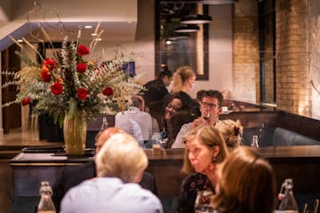 In late 2020, tables were spaced out and plexiglass divided dining areas at Alma. 