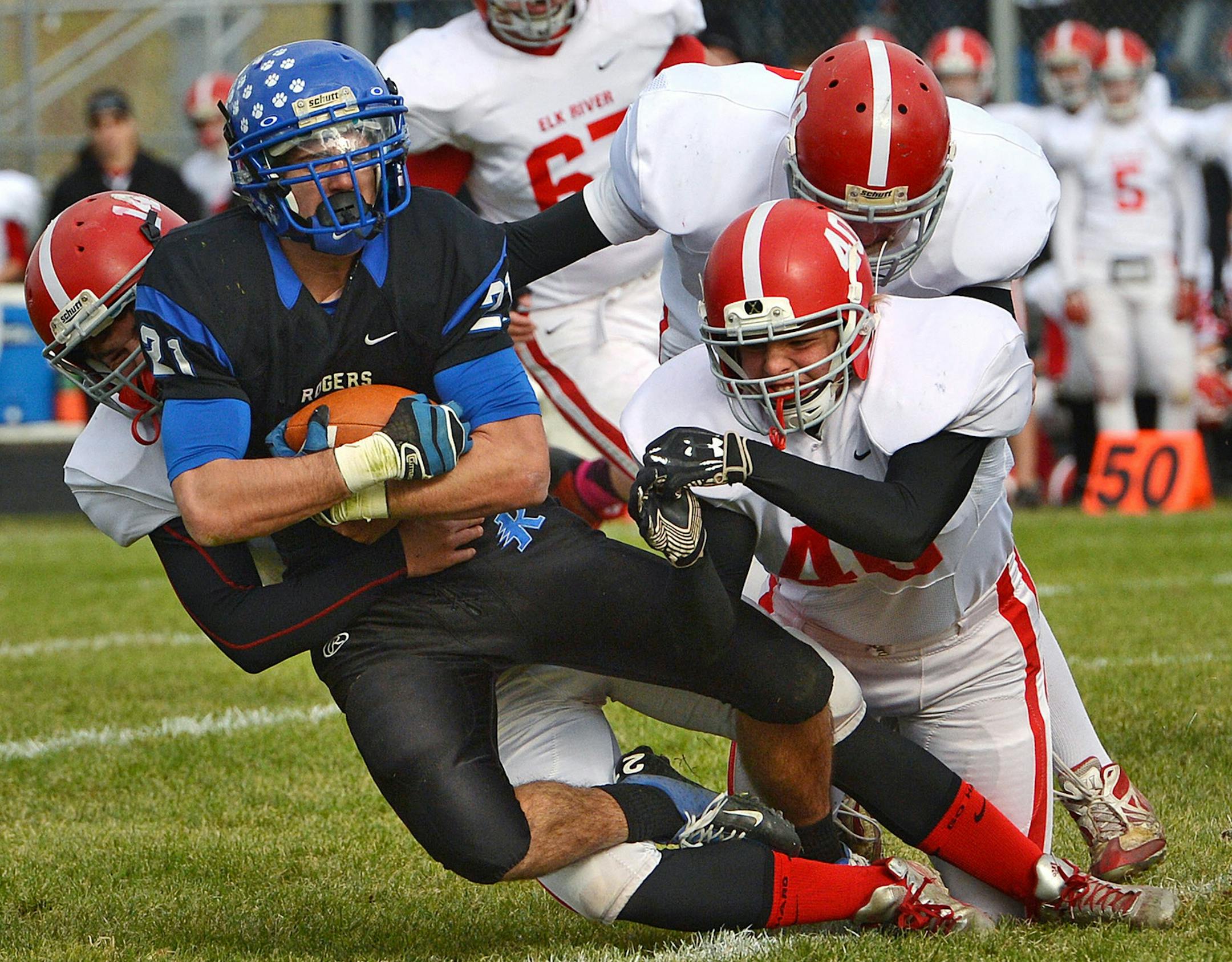 Rogers' senior Nate Weber is tackled by Elk River defense after a carry during the first half of the Class 6A semifinals game Saturday, October 26 at Rogers High School. ] (SPECIAL TO THE STAR TRIBUNE/BRE McGEE) **Nate Weber (21) ORG XMIT: MIN1310261821183077