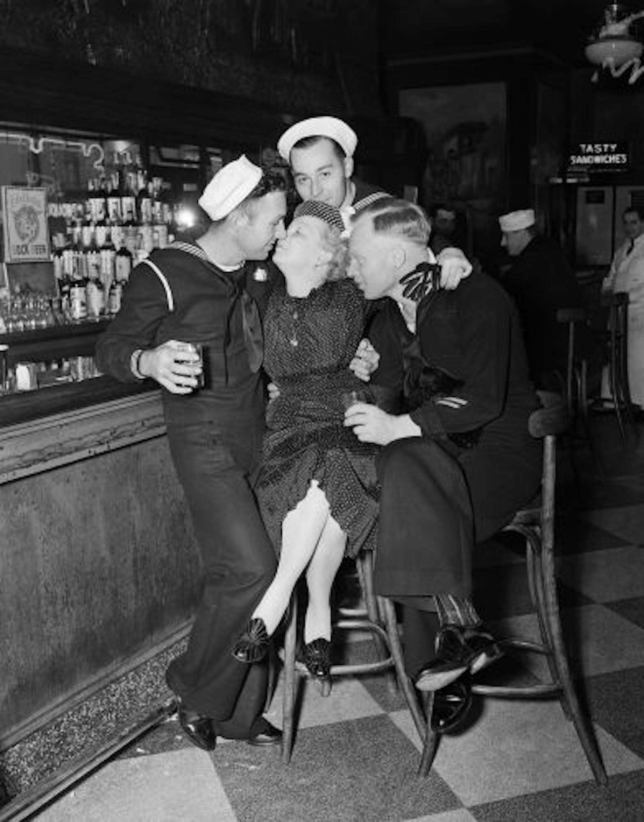 Three sailors on shore leave cozy up with a woman named Georgia at a bar in New York on April, 13, 1939. The vanguard of the U.S. Naval fleet is in town for the World's Fair in Queens.