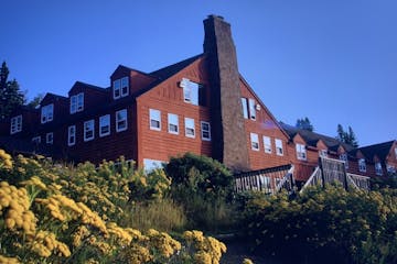 A summer view of the Mesaba Red-painted Lutsen Lodge from the cobblestone beach.