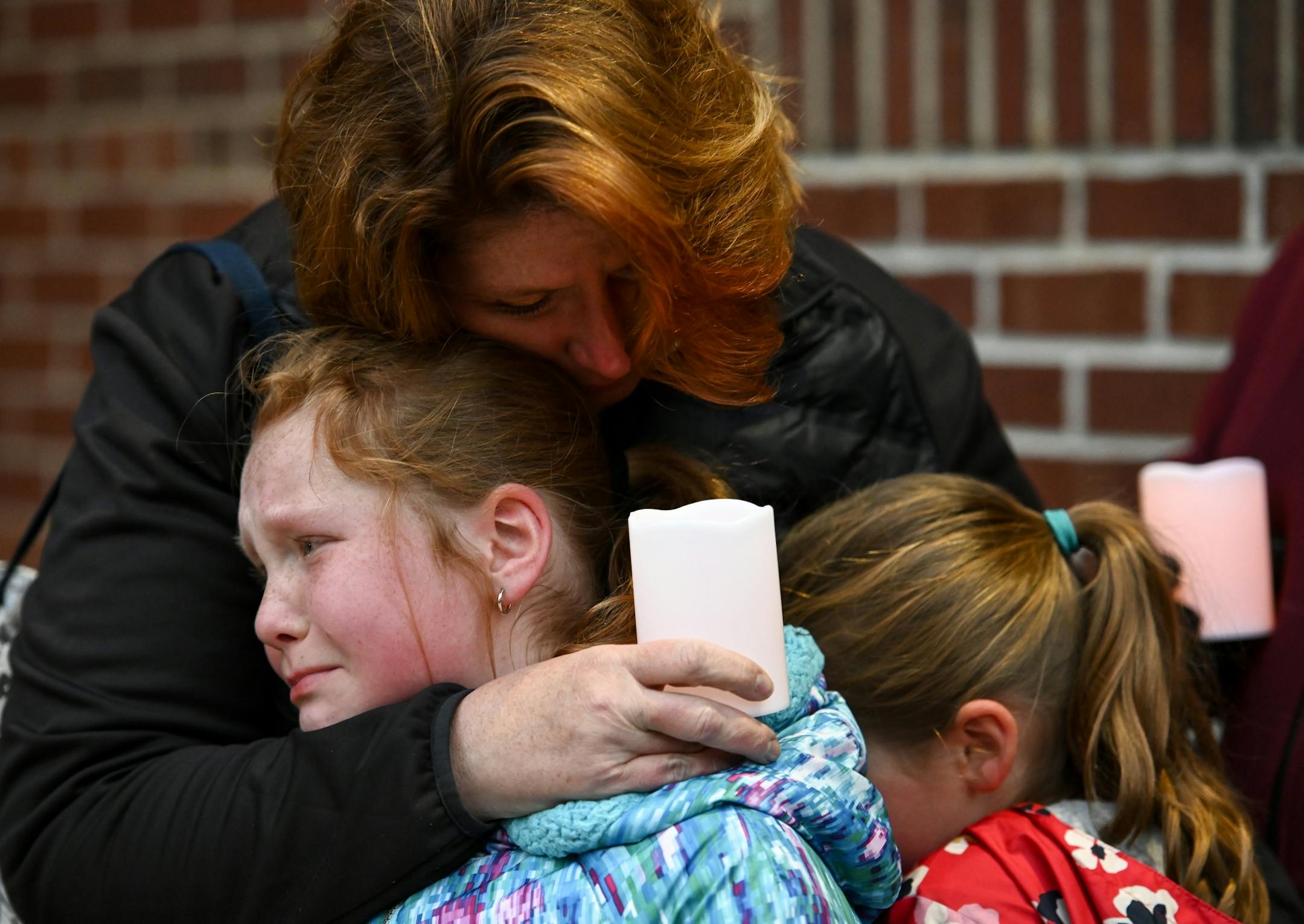 Sarah Matlock, of St. Paul, embraced her two daughters, Teyla, 8, left, and Carter, 7, as the three were overcome with emotion Friday night as they stood outside of Shir Tikvah to support members of the Minneapolis Jewish community following last week's shooting at a synagogue in Pittsburgh, leaving 11 dead. They attended the service with a group of parishioners from the Saint Joan of Arc Catholic Church.