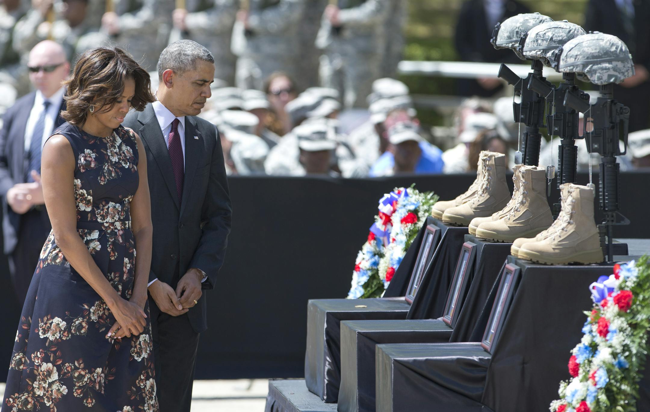 President Barack Obama and first lady Michelle Obama pay their respects during a memorial ceremony, Wednesday, April 9, 2014, at Fort Hood Texas, for those killed there in a shooting last week. President Barack Obama is reprising his role as chief comforter as he returns once again to a grief-stricken corner of America to mourn with the families of those killed last week at Fort Hood and offer solace to the nation.(AP Photo/Carolyn Kaster)