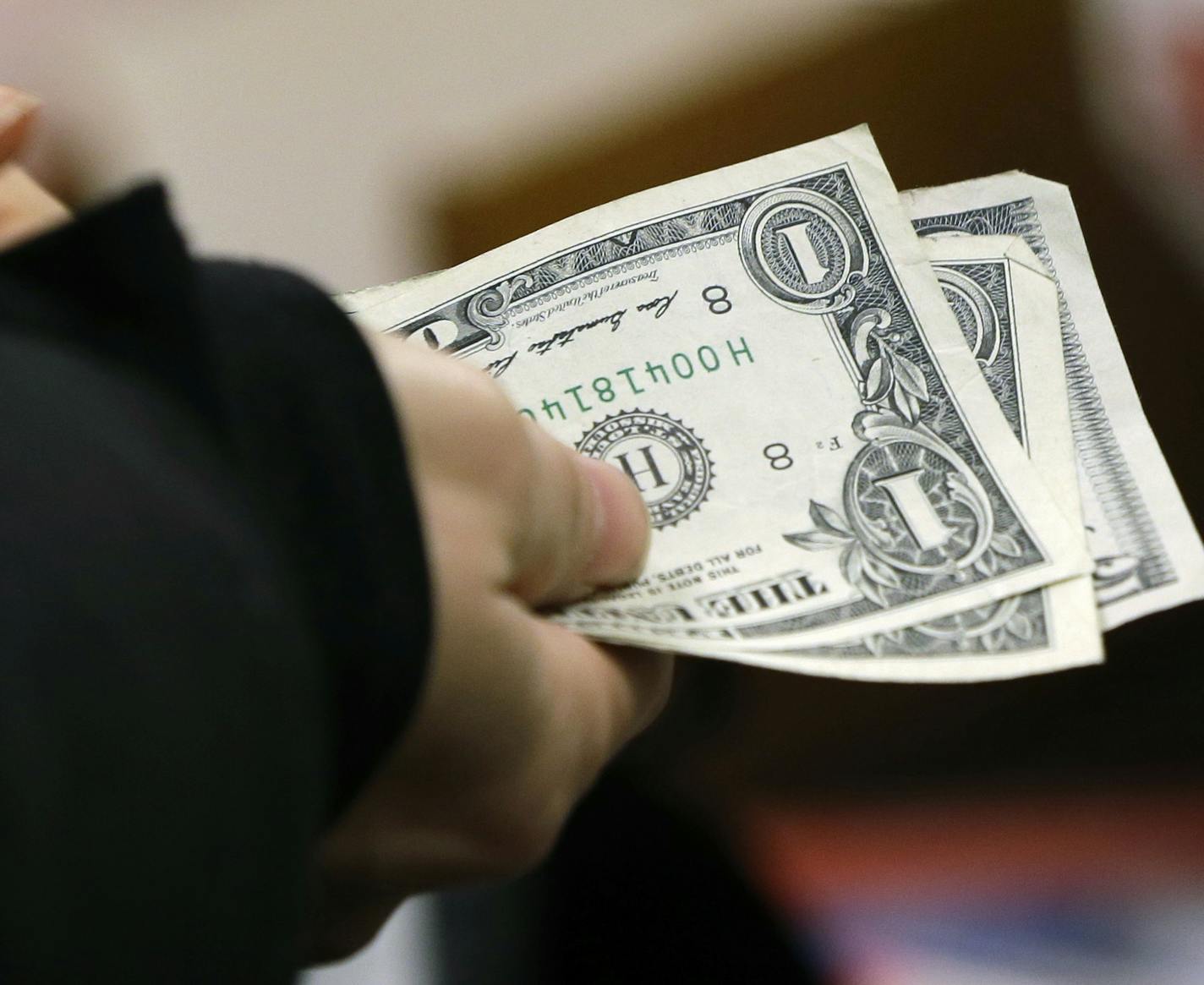 FILE - In this Thursday, Nov. 27, 2014, file photo, a woman pays for merchandise at a Kohl's department store in Sherwood, Ark. A New Year&#xed;s resolution to save just one percent more a year can make a big difference when it comes time to retire, according to financial experts. (AP Photo/Danny Johnston, File)