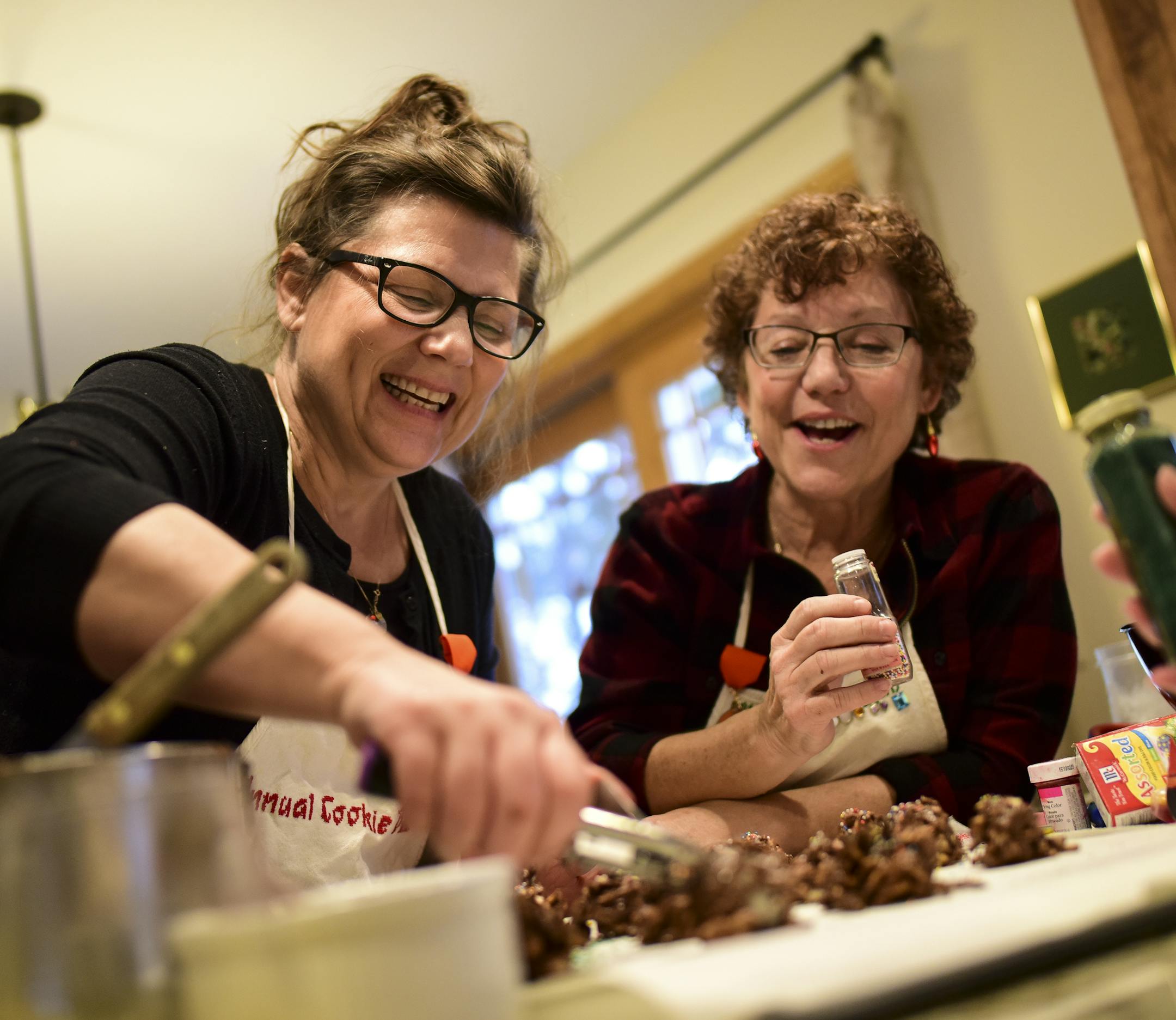 Susan Marek, left, and Jan Armstrong worked on making some "haystacks," cookies made with chow mein noodles, peanuts, marshmallows, semisweet chocolate and butterscotch, during Saturday's cookie bake. ] Aaron Lavinsky • aaron.lavinsky@startribune.com Ann Bailey and her husband, Randy, hosted a group of close friends for their 30th annual cookie bake in their home in Apple Valley on Saturday, Dec. 8, 2018. Each baker has a special hand-made cookie bake apron, cross-stitched with their name