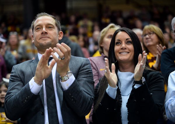 New Gophers football coach P.J. Fleck and wife Heather Fleck clapped along during the Gophers fight song Saturday night at the end of the first half o
