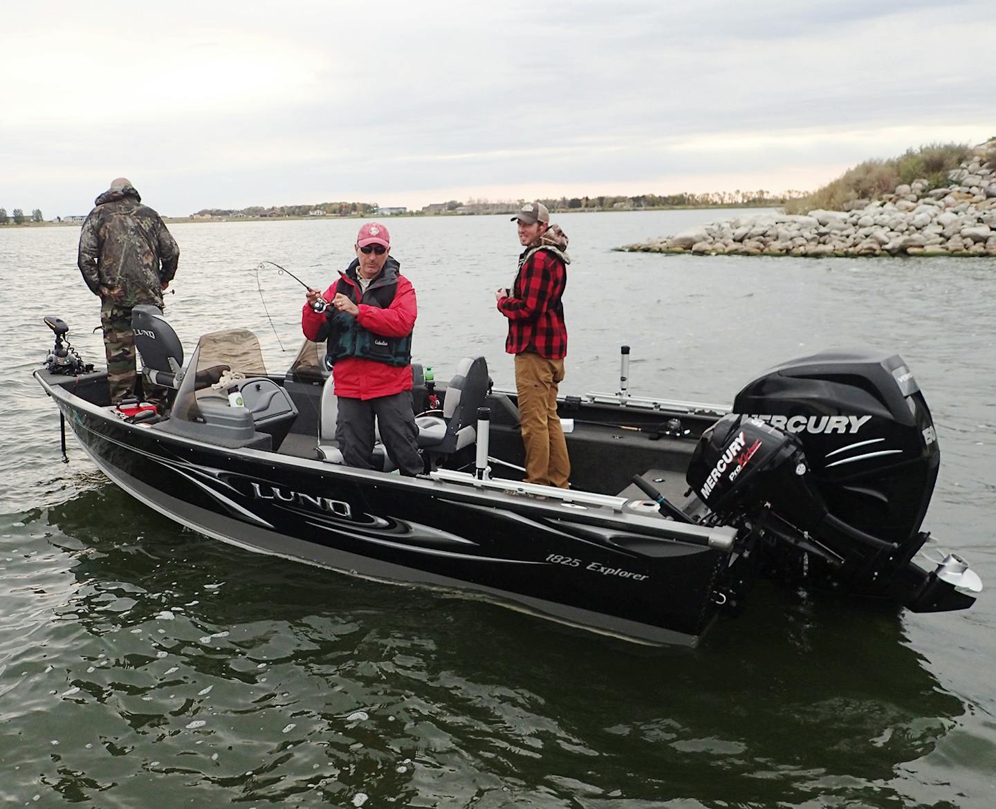 Patrick Kennedy of Mendota Heights kept a tight line on a walleye he caught while jigging on Devils Lake in the shadow of a highway bridge. Jeremy Maslowski of Tower, Minn., watched the tussle while Mike Gordley of St. Paul (left) waited for the next bite.