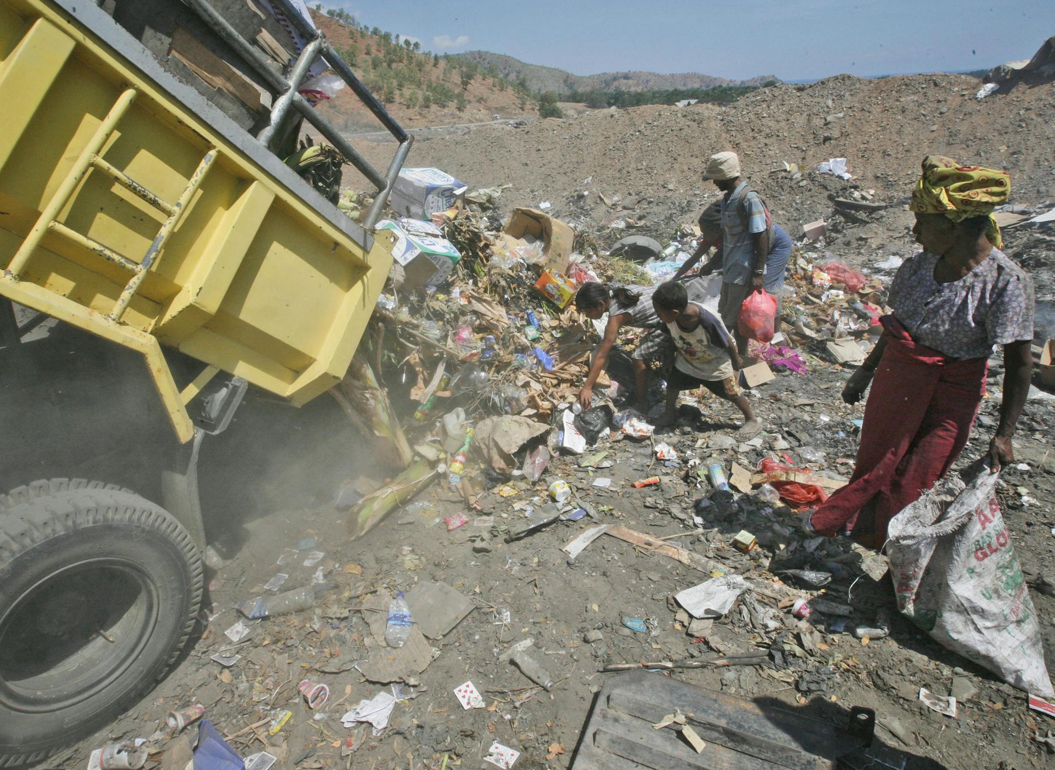 **ADVANCE FOR TUESDAY, SEPT. 8** This Aug. 26, 2009 photo shows people scavenging through a garbage dump in Dili, East Timor. A decade after its breakaway from Indonesia, East Timor is still struggling with poverty, unemployment, the building of infrastructure, rural development and private sector growth despite the billions of dollars worth of foreign assistance. (AP Photo/Dita Alangkara)