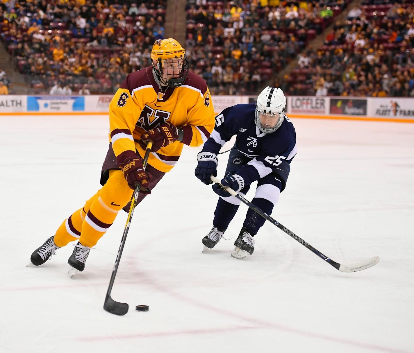 Minnesota Golden Gophers right defenseman Ryan Collins (6) eyed the goal while being defended from behind by Penn State Nittany Lions forward Denis Smirnov (25).