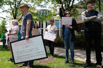 Heidi Fellner of Minneapolis, right, waved to passing cars as she stood with fellow protesters outside the theater last month organized by survivors o