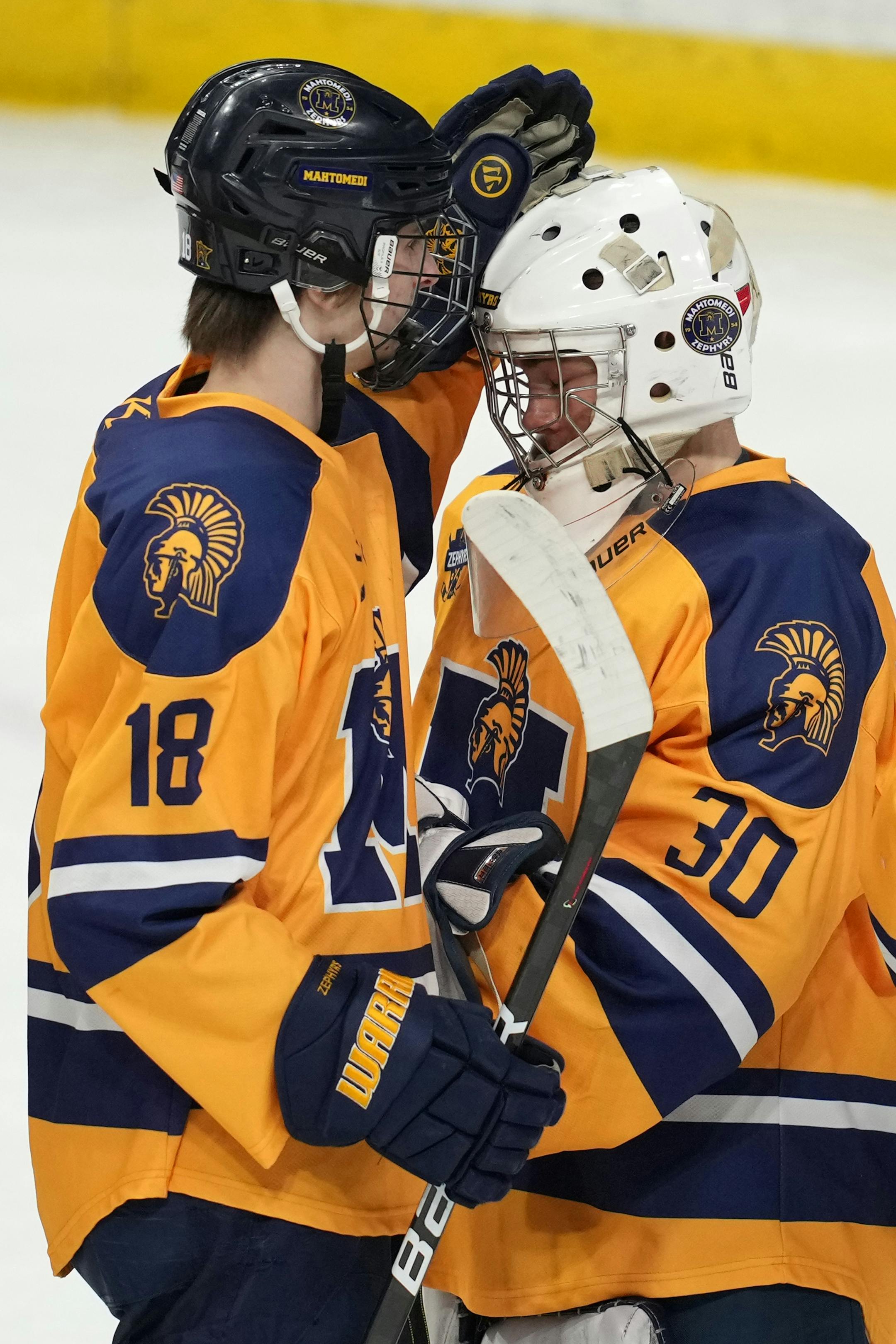 Mahtomedi goaltender Charles Brandt (30) is congratulated by Mahtomedi forward Gene Wegleitner (18) after the win at the end of the third period of a MSHSL Class 1A quarterfinal hockey game between Alexandria and Mahtomedi.