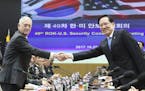 U.S. Defense Secretary Jim Mattis, left, and South Korean Defense Minister Song Young-moo shake hands while posing for a photo prior to the 49th Secur