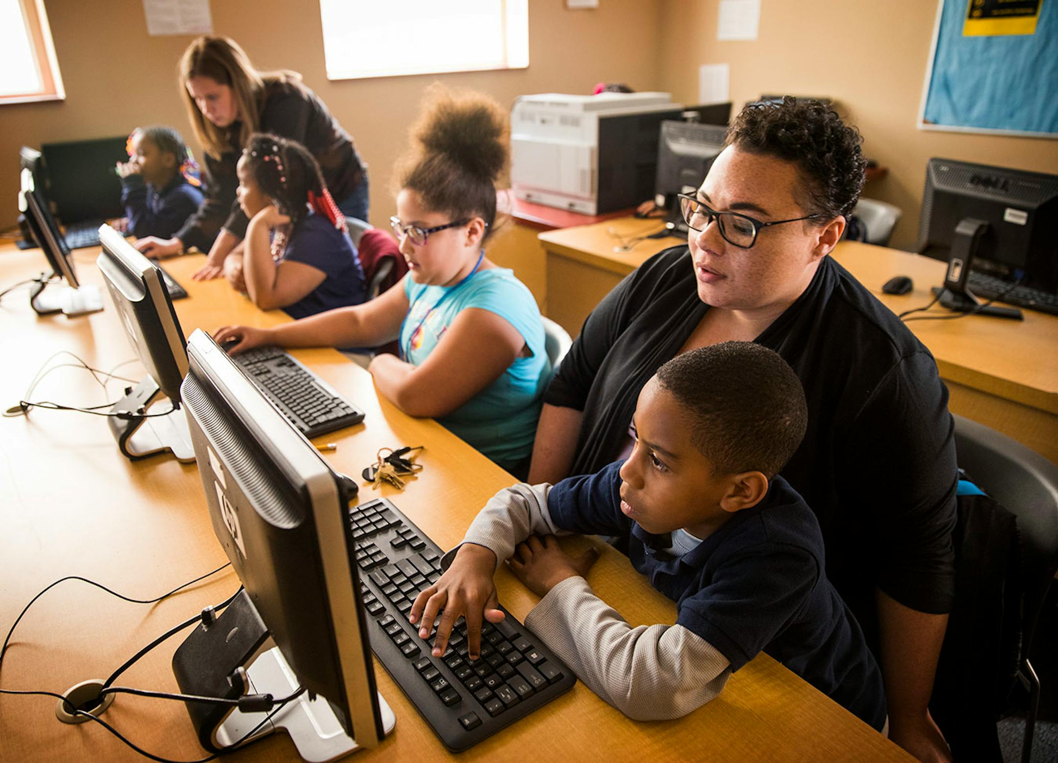 Cyrus Beasley, 9, gets from help with his computer from Catrice O'Neal, the director of Out of School Time programs.