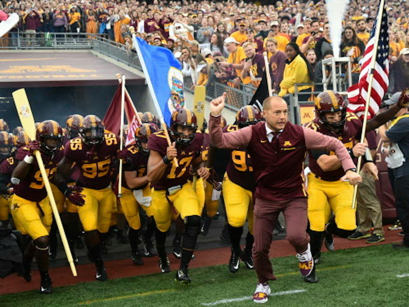 FILE - In this Oct. 21, 2017, file photo, Minnesota coach P.J. Fleck leads his team onto the field for an NCAA college football game against Illinois in Minneapolis. Minnesota faces Northwestern this week. Fleck recalls the advice about running a program he got from Northwestern's Pat Fitzgerald over lunch many years ago. It still resonates. (AP Photo/John Autey, File)