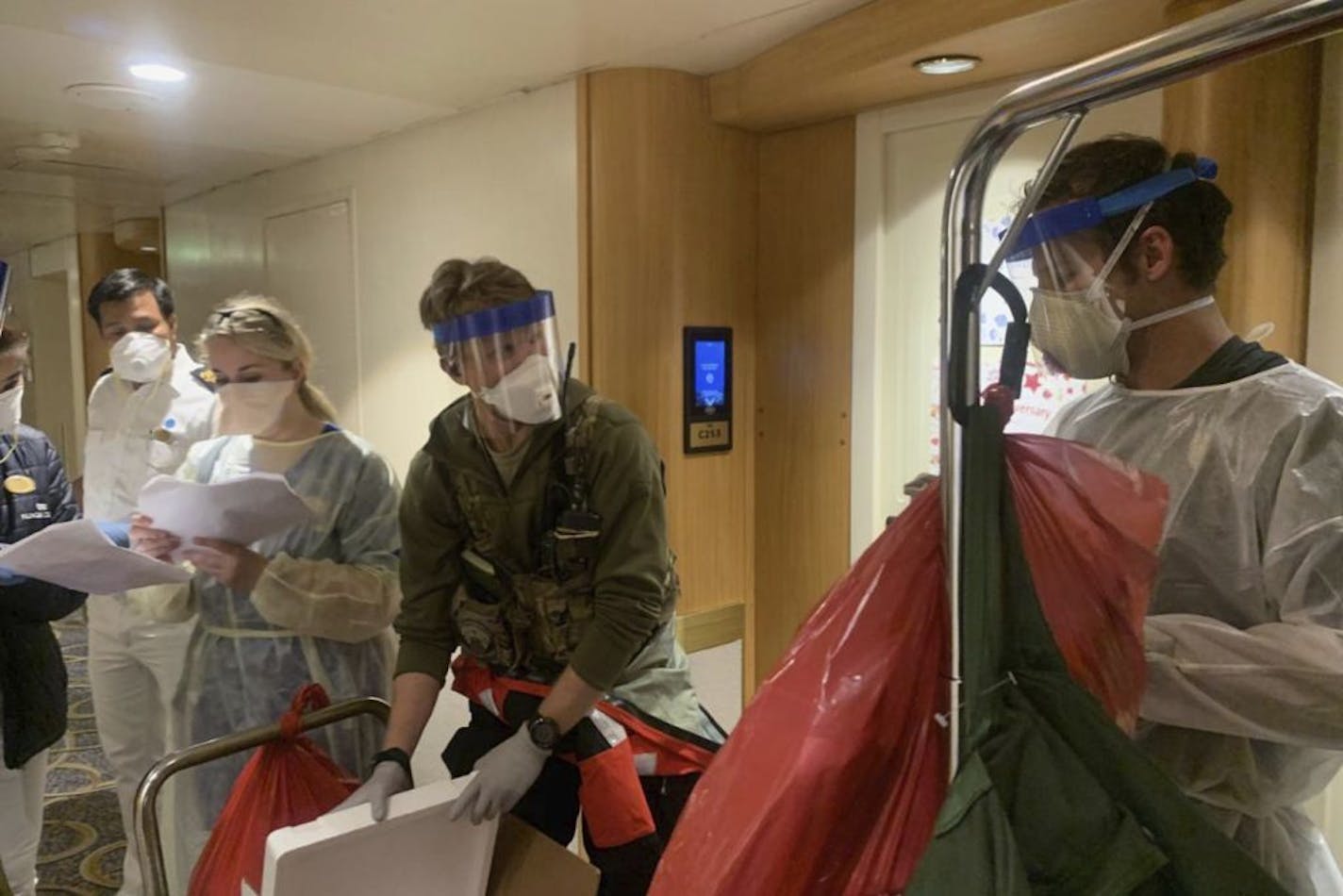 In this Thursday, March 5, 2020, photo, released by the California National Guard, Guardian Angels, a group of medical personnel with the 129th Rescue Wing, working alongside individuals from the Centers for Disease Control and Prevention after delivering virus testing kits to the Grand Princess cruise ship off the coast of California.