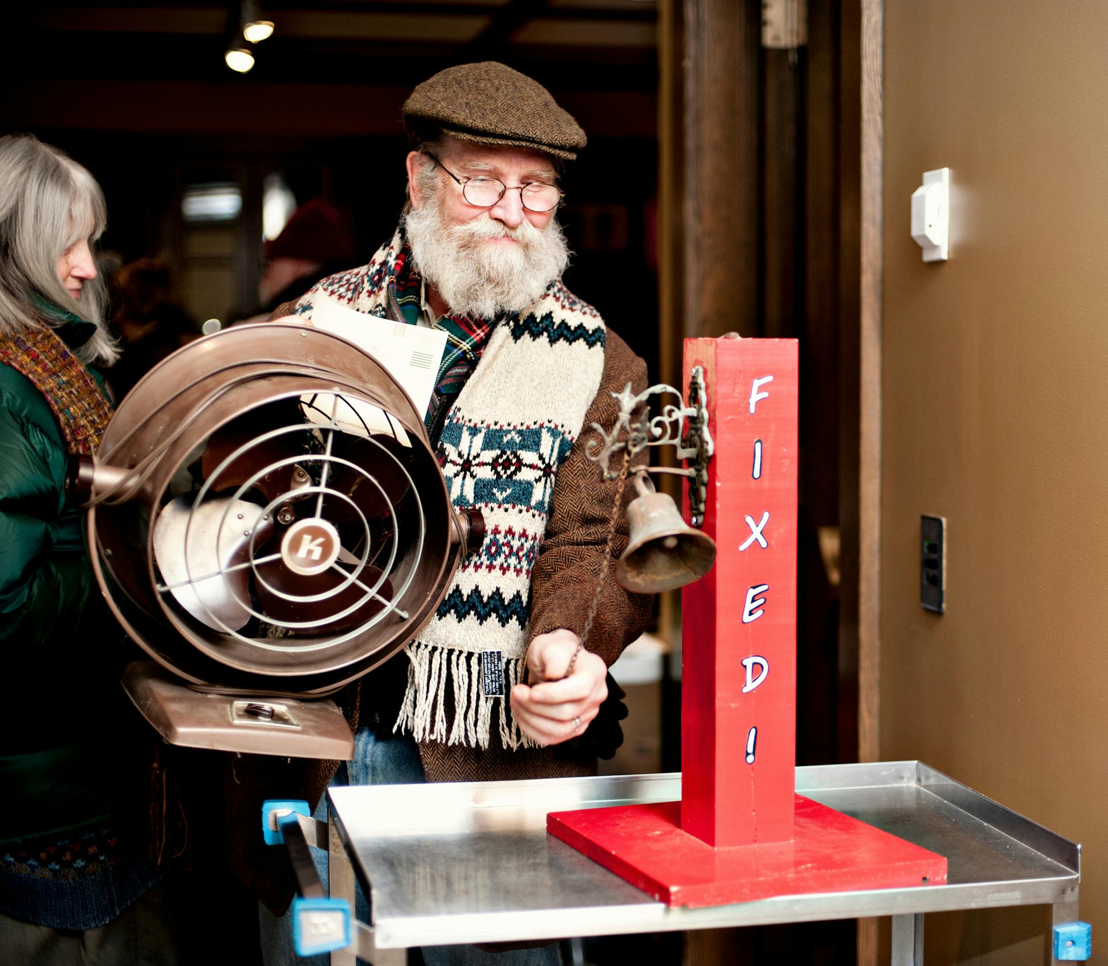 A patron leaves The Fix It Clinic at the Bakken Museum with his newly repared fan, ringing the "fixed" bell as he exits. Photo by Leslie Plesser / Star Tribune