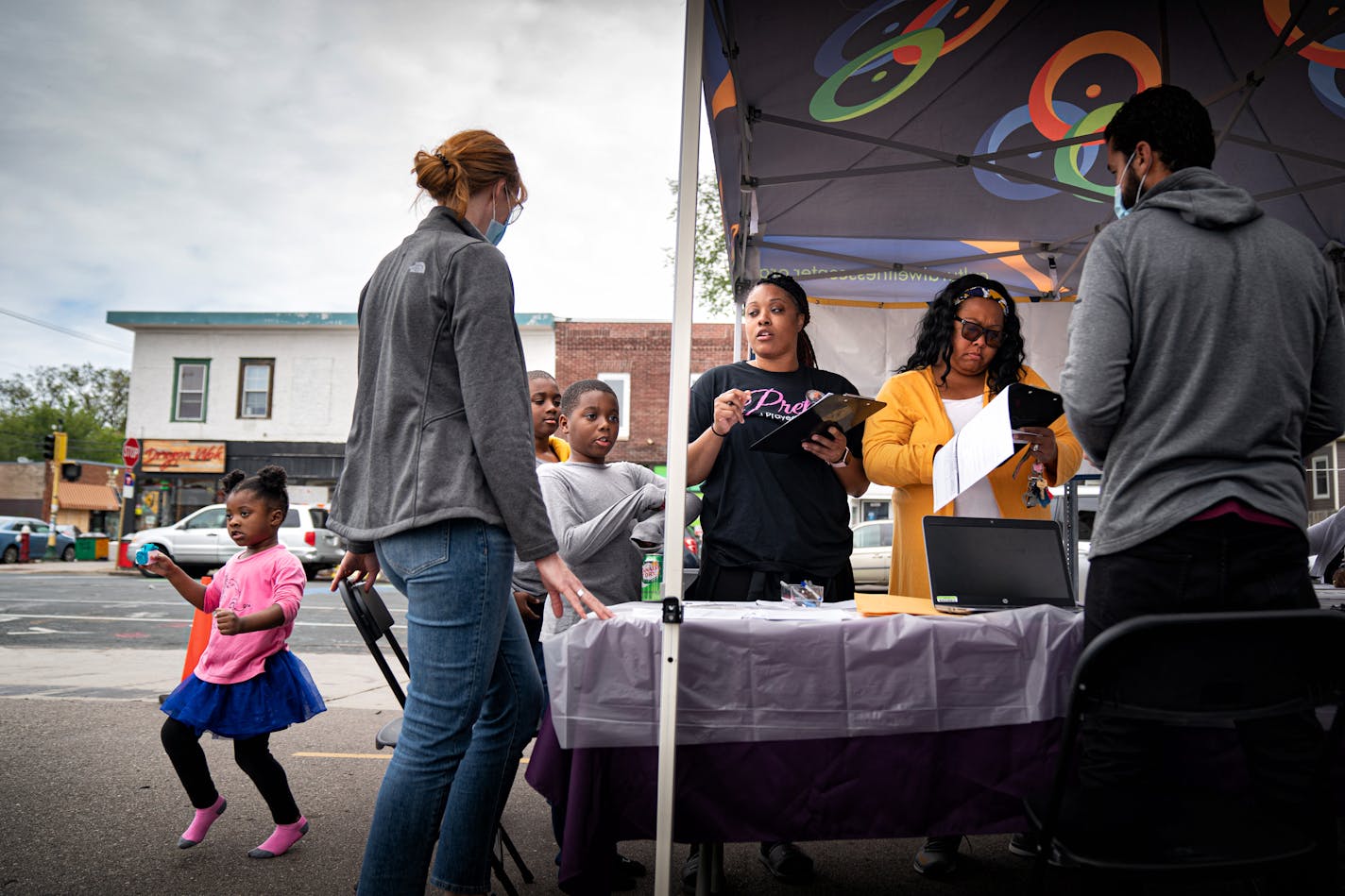 With her kids, Faith, 3, Jerimiah, 11 and Isaiah, 9, at her side, Shontae Jones, center, and her friend Angie Evans, right, signed up for their second dose of COVID vaccine. Faith, 3, danced to the music playing in the background.