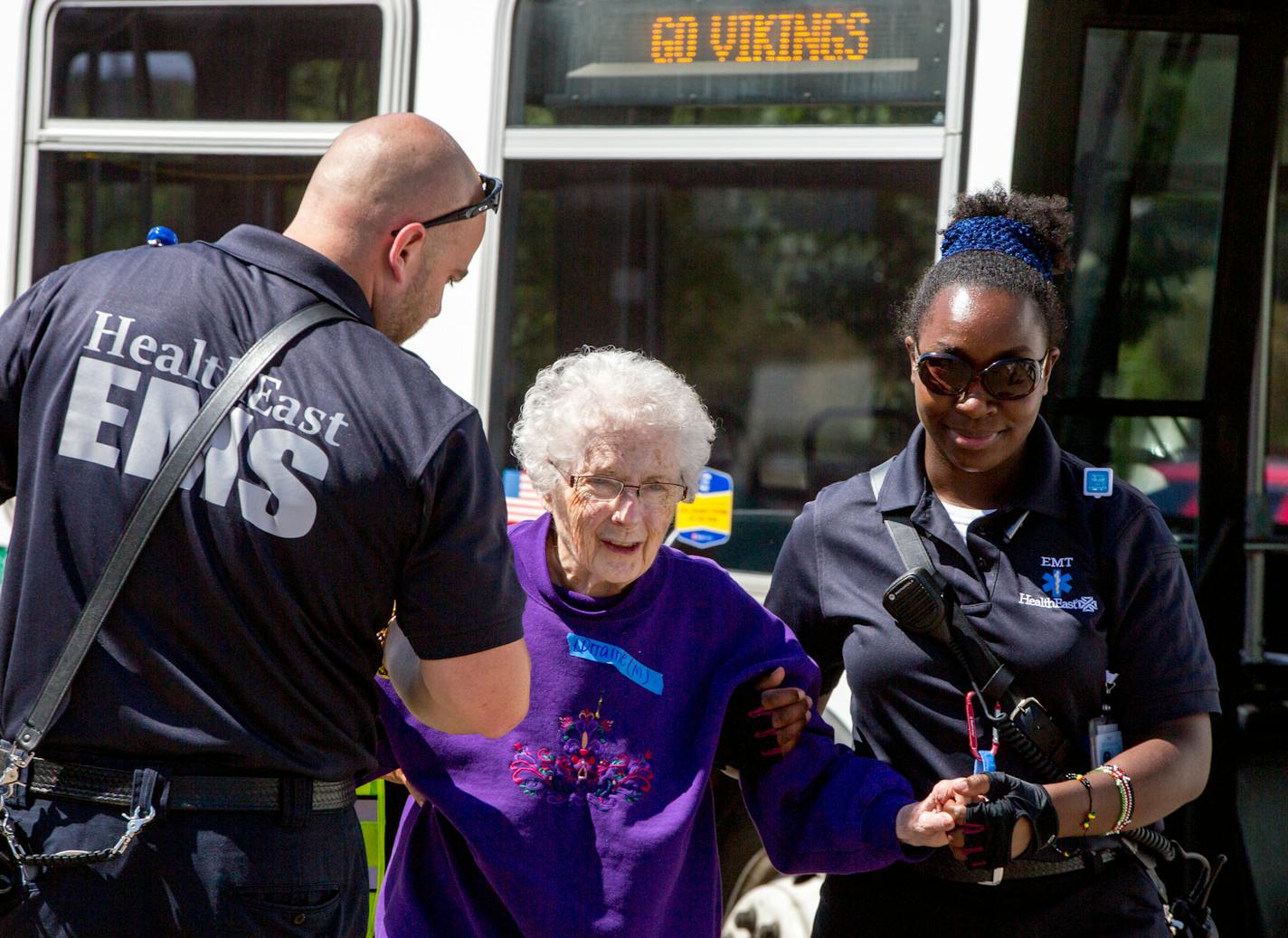 EMS helps a woman off of the bus and back to White Pine Senior Living in Mendota Heights after they were evacuated following an alleged armed robbery on July 29, 2017. ] COURTNEY PEDROZA &#x2022; courtney.pedroza@startribune.com; Police are currently responding to an active situation following an alleged armed robbery in Mendota Heights. July 29, 2017.