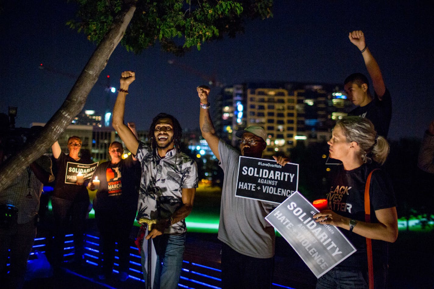 A few dozen people quickly came together Saturday night to hold a vigil in Gold Medal Park in Minneapolis to show solidarity with Charlottesville, Va.