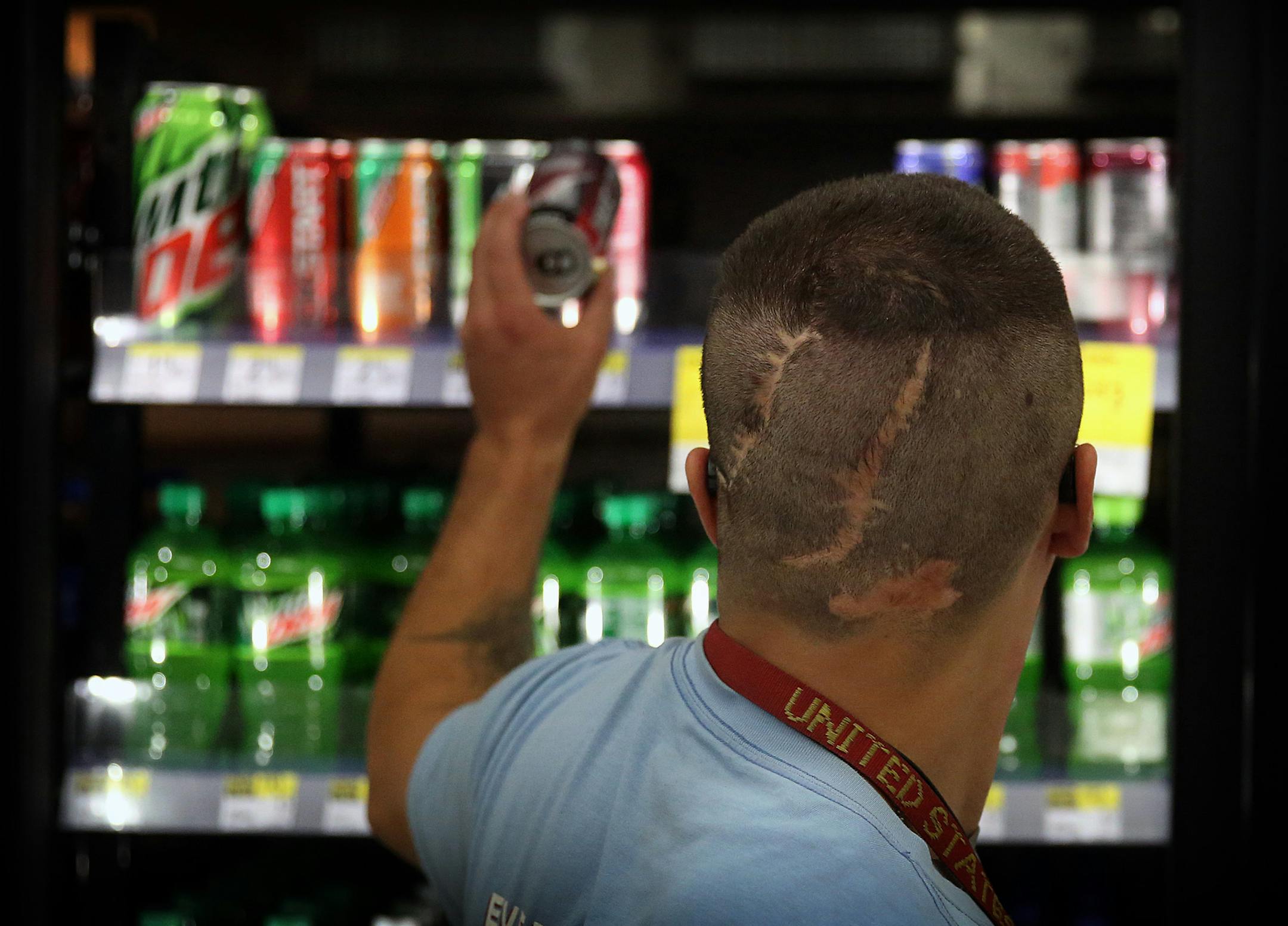 Kyle Anderson, a military veteran who was wounded in Iraq, stocks shelves at a Walgreens drug store in Inver Grove Heights.
