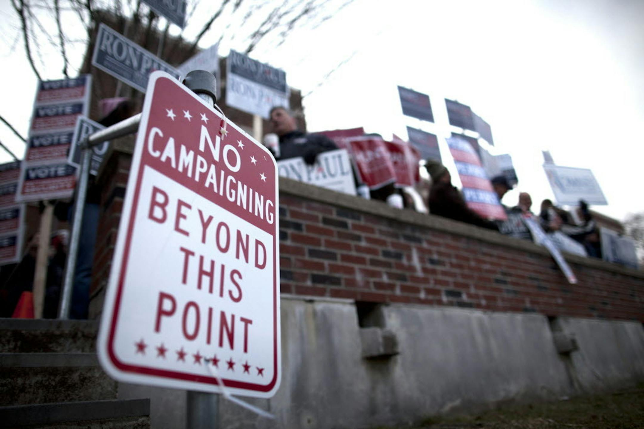 Supporters of Republican presidential candidates gather outside the Webster School in Manchester, N.H., Tuesday, Jan. 10, 2012, where primary voting was taking place.