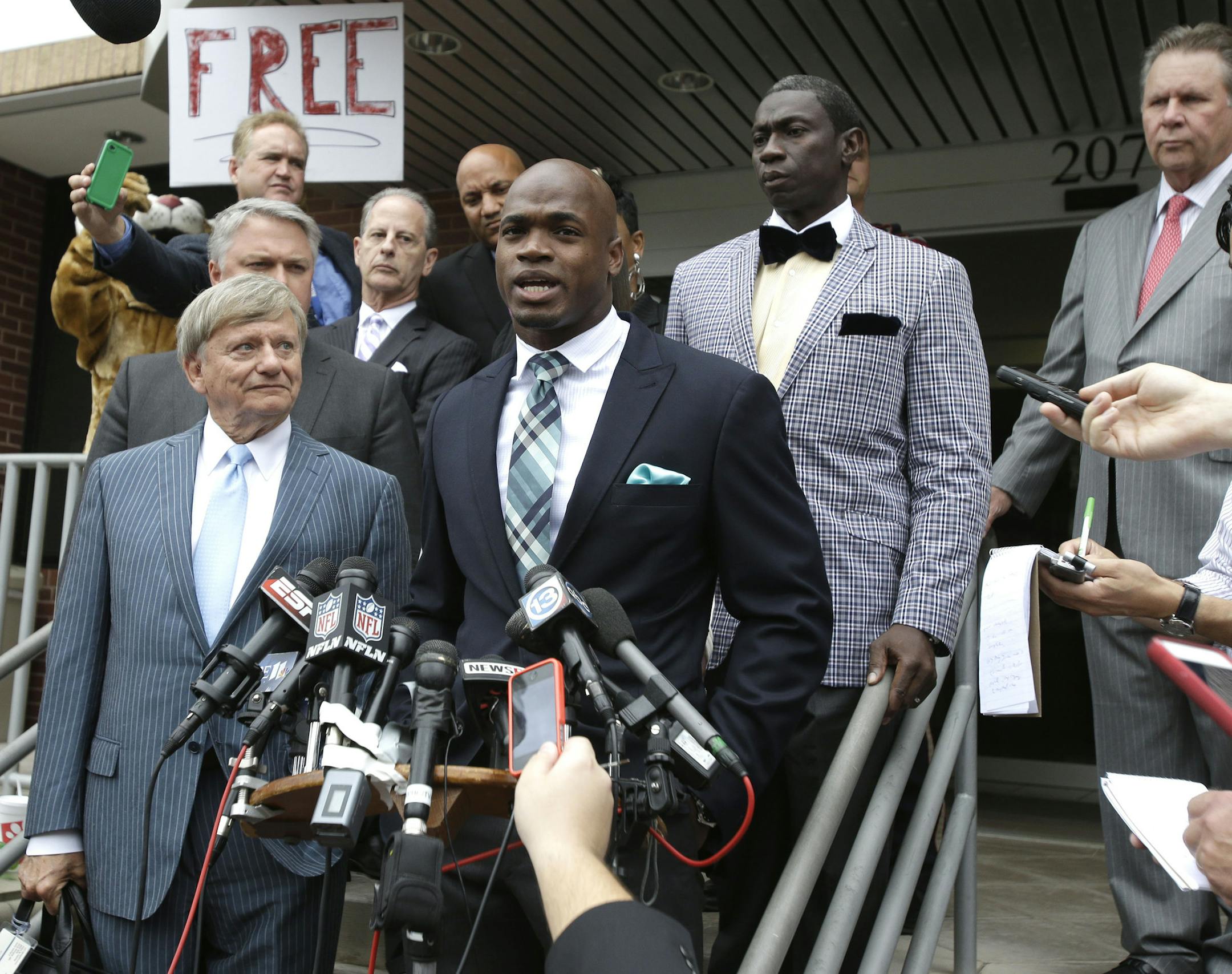 Minnesota Vikings running back Adrian Peterson, center, and his attorney Rusty Hardin, left, speak to the media after pleading no contest to an assault charge Tuesday, Nov. 4, 2014, in Conroe, Texas. Adrian Peterson avoided jail time on Tuesday in a plea agreement reached with prosecutors to resolve his child abuse case. (AP Photo/Pat Sullivan)