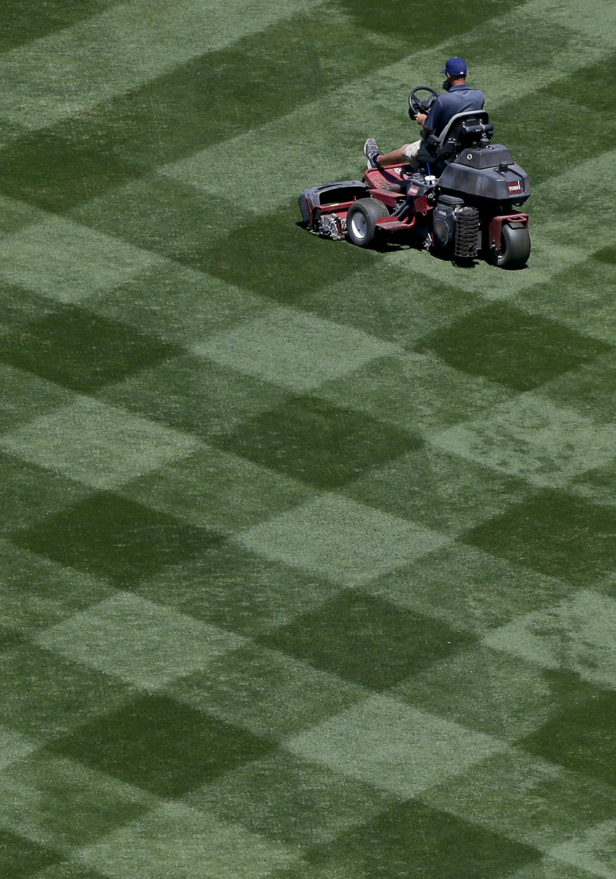 A grounds crew member cuts the grass before a baseball game between the Los Angeles Dodgers and the Colorado Rockies, Friday, April 17, 2015, in Los Angeles. (AP Photo/Jae C. Hong) ORG XMIT: LAD101
